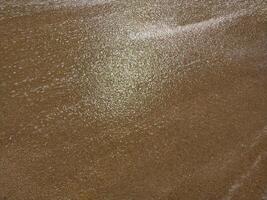 Fine golden sand covering a beach during a suns, creating a serene and tranquil atmosphere for relaxation photo