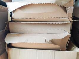 Stack of damaged cardboard boxes, showing wear and tear. Ideal for illustrating shipping, moving, recycling, or the concept of disposal. The image has a rustic, realistic aesthetic. photo