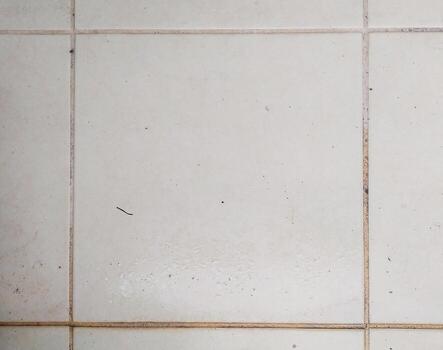 Closeup of slightly dirty, offwhite square tiles. Minimalist texture ideal for backgrounds, website design, or architectural projects. Subtle grunge adds character. photo