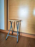 Compact, lightweight, foldable stool with a light wood top and silver frame. Perfect for small spaces, extra seating, or as a side table. Ideal for home, office, or travel. photo