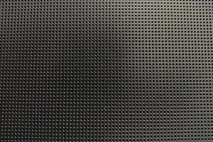 Highresolution image of a dark gray perforated metal sheet. Uniformly spaced round holes create a textured background ideal for industrial, tech, or abstract design projects. photo