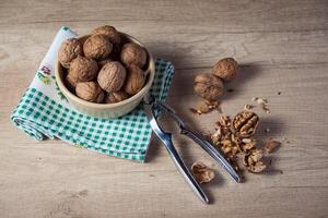 Walnuts in a bowl and scissors on a wooden table photo