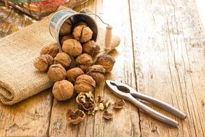 A wooden table with a bunch of nuts and a pair of scissors photo