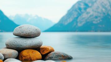 Serene Stacked Stones by Calm Lake with Mountain View Peaceful Nature Scene photo