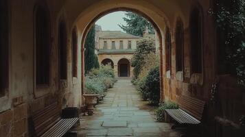 Serene Courtyard View Through Archway Tranquil Stone Pathway Benches and Ancient Architecture photo