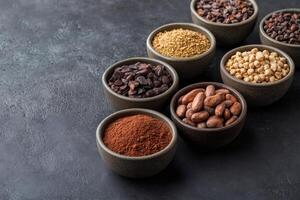 Cocoa products showing cocoa beans, nibs, powder, butter and liquor in bowls photo
