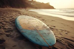 Surfboard lying on the beach at sunset with people walking in the background photo