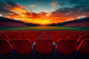 Empty stadium with red seats and dramatic sunset illuminating the field photo