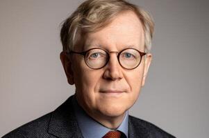 A headshot of a man in glasses, looking intently at the camera photo