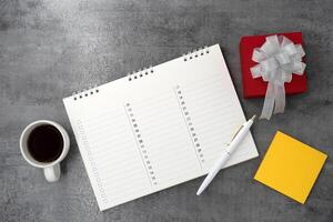 Gift box with calendar and coffee on stone texture background. Planning. Flat lay. Top view. photo