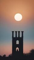 A simple vertical image of an ancient tower silhouette stands against a gradient sky, framed by generous negative space. photo