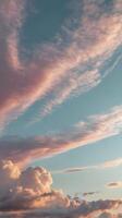 Long, wispy clouds in a pastel-colored sky create a vertical layout with a minimalist vibe and ample room for copy. photo