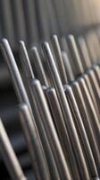 A vertical shot of evenly spaced metal bars under soft lighting, providing a minimalist design with clear negative space for text. photo