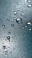 Close-up vertical photo of water droplets on glass, with blurred background providing ample copy space.