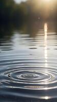 A vertical composition of gentle ripples on a serene water surface, evoking calmness with open space for text. photo