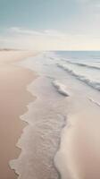 A vertical landscape of a calm seaside, with delicate waves washing over the sand, soft pastel tones, and a wide sky for adding text. photo