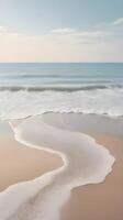 A vertical image of a quiet seashore with gentle waves meeting the sand, soft pastel colors, and sky for text placement. photo
