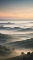 A serene vertical composition showcasing hills wrapped in soft morning mist, muted hues, and a sky perfect for text placement. photo