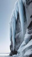 A vertical capture of a frozen cliff, detailed with cascading ice, and a wide expanse of blank sky perfect for text. photo
