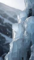 A vertical image of a detailed icy cliff with flowing ice patterns, framed by a clear sky offering space for text. photo