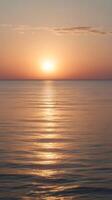 A peaceful vertical image of a pastel sunrise over a calm horizon, with clear space for text or design elements. photo