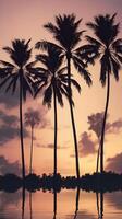 Vertical capture of shadowed palm trees standing tall against a serene dusk sky, leaving ample room for copy. photo
