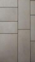 A vertical image of a textured concrete wall in neutral tones, providing an excellent base for minimalistic designs. photo