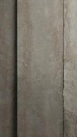 A vertical shot of a textured concrete wall in soft tones, ideal for minimalist and clean designs. photo