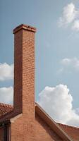 A detailed vertical shot of a weathered brick chimney set against a soft, empty sky, offering space for text. photo