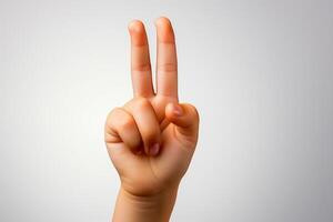 Child's hand showing the number 2 with fingers isolated on white background.Freedom sign. photo