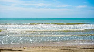 Tranquil Beach with Gentle Waves and Clear Sky photo