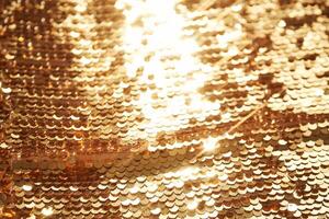 Abstract festive gold background made of sequins. photo