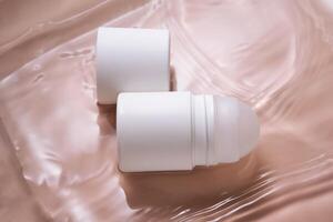 Roll-on deodorant on a soft pink background in water. photo