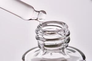 Cosmetic bottle with a pipette showing the texture of the serum. photo