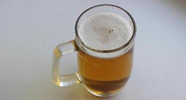 Huge beer glass with classic handle filled of craft brown beer covered with foam isolated on white photo