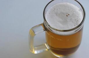 Rich color of indian pale ale in a classic beer glass on white surface top view. Foam On Pale Ale In A Beer Mug Extreme Closeup Stock Photo