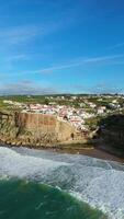 Azenhas do Mar Village on Sunny Day. Cliffs and Waves of Atlantic Ocean. Portugal. Aerial View. Orbiting. Vertical video