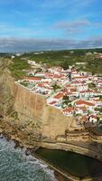 Azenhas do Mar Village on Sunny Day. Cliffs and Waves of Atlantic Ocean. Portugal. Aerial View. Moving Backwards and Upwards. Vertical video