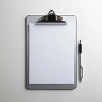 A clipboard with a pen and paper on a white surface photo