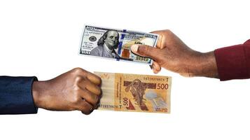 USA Dollar West African CFA Franc currency pairing.Black African hands holding exchanging comparing two bank notes. USA versus CFA. Weighing Currencies against each other. Exchange rate photo