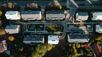 Top view of modern residential neighborhood with contemporary apartment buildings, green spaces, parking areas and well-maintained pathways on sunny day video