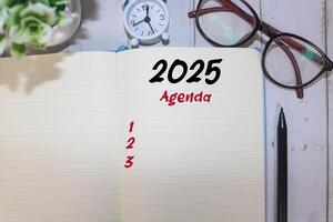 2025 New Year resolutions goals, plans, and resolutions concept. Planning checklist 2025 target on notebook with office desk background. 2025 agenda in notebook on table photo