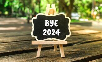 Writing on the word goodbye 2024 on the blackboard. Bye 2024 on paper, hello 2025 photo