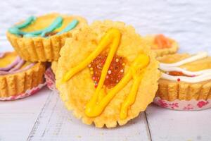 Close up mini pies with colorful toppings. small tart cakes and pies on white background. Chocolate flavored cake photo