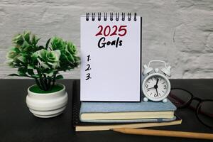2025 New Year resolutions goals, plans, and resolutions concept. Planning checklist 2025 target on notebook with office desk background. 2025 goals in notebook on table photo