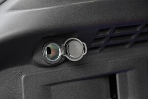 Close up of a vehicle's 12V power outlet with a protective cover photo