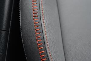 Close up of gray leather upholstery with orange stitching High quality texture and detail photo
