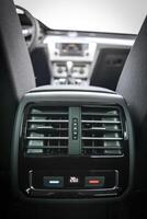Rear passenger AC vents in a modern car interior Climate control display showing temperature photo