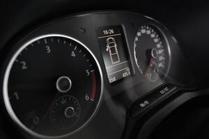 Close up of a car's dashboard showing the speedometer tachometer and digital display photo