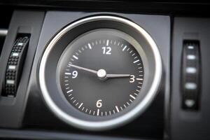 Close up of an analog clock in a vehicle's dashboard photo